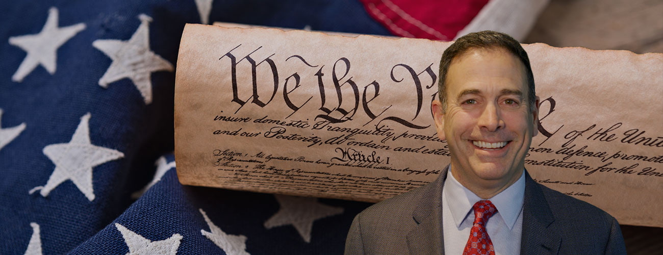 United States Constitution, rolled in a scroll on a vintage American flag and rustic wooden board